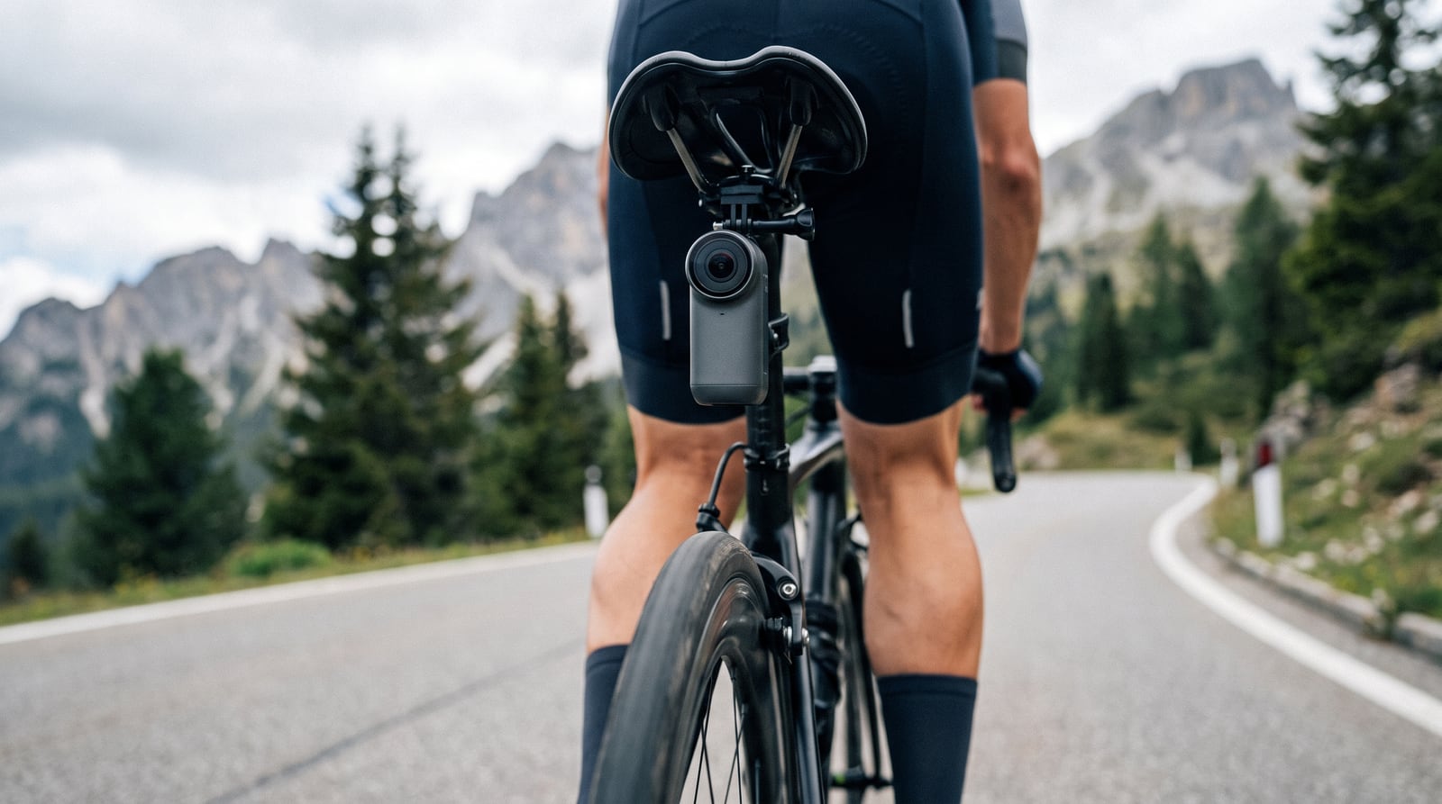 A slim action camera mounted under a road bike saddle with its lens facing straight back
